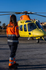 Paramedic looking at the medical helicopter that is landed at the airfield. © Martin