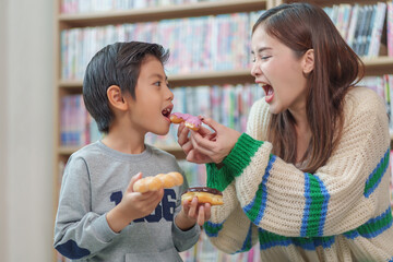 babysitter teacher feed snacks to student during their lunch break,a young attractive asian female give a sweet to pupil in the room