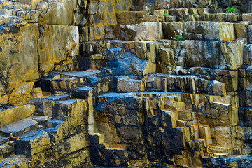 Complex cliff face with cubic rock shapes and contrasting tones