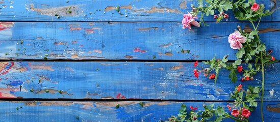 Fototapeta premium Blue painted wooden planks adorned with flowers providing a space for text within the copy space image