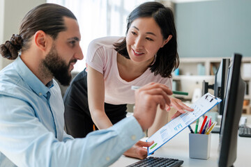 Successful colleagues, businessman and businesswoman, Arab man and Asian woman working together