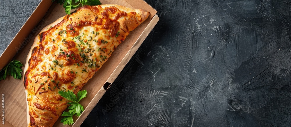 Fototapete Cardboard boxed pizza calzone set on a dark backdrop with ample space for text alongside the image