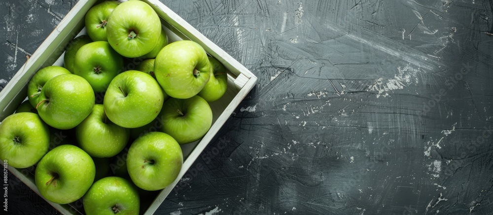 Poster Fresh green apples arranged in a white wooden box on a rustic gray table with copy space image available