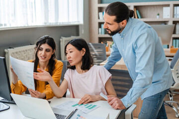 Diverse team analyzing financial reports and developing growth strategy