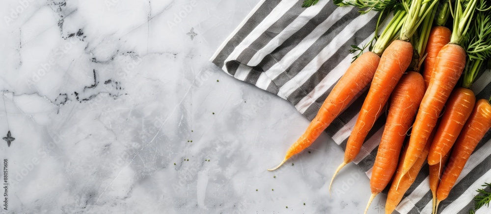 Poster fresh baby peeled carrots on a marble surface with a striped napkin emphasizing a nature inspired di