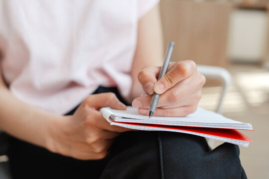 Woman taking notes in meeting at office, selective focus