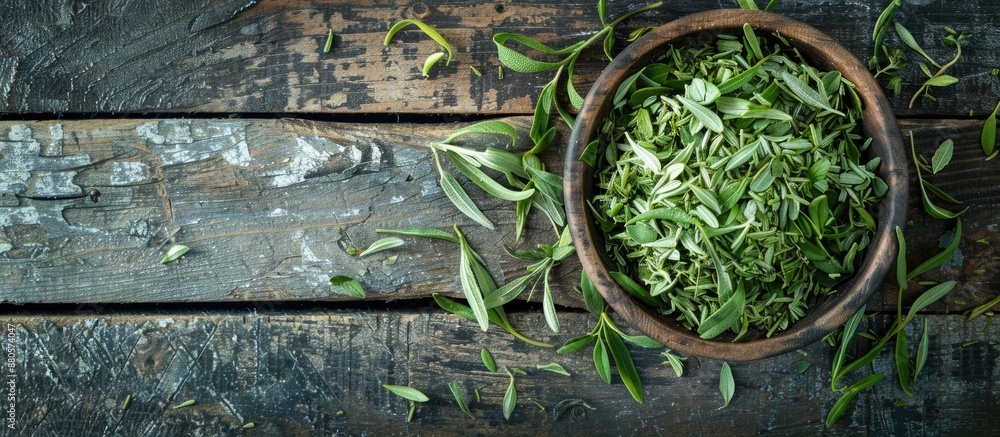 Poster tarragon dried in a bowl on a wooden table with copy space image