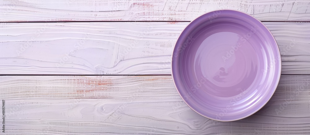 Poster Light wooden background with a purple plate on it creating a serene image with a copy space image