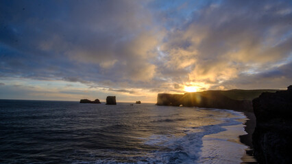 Sunset over the dramatic Dyrh&oacute;laey rock formations and coastline in Iceland.