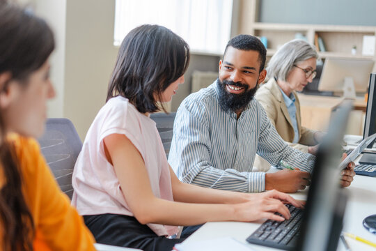 Diverse team of programmers working on computers in modern office