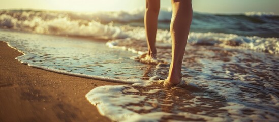 Closeup image of a woman walking on a sandy beach near the sea with a clear area for adding text copy space image