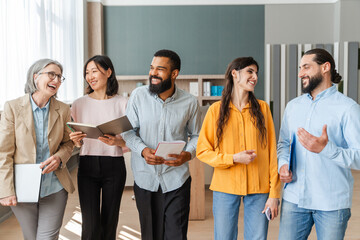 Diverse group of professionals walking and talking in an office