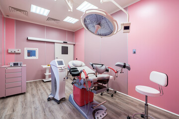 Gynecological surgery cabinet with different medical equipment. Interior in pink colors.