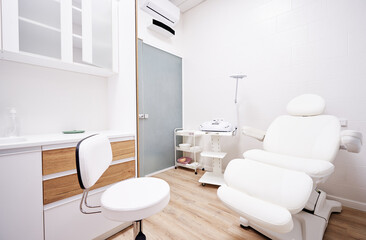 Light interior of modern aesthetic cosmetolody clinic with chair for patient and equipment for...