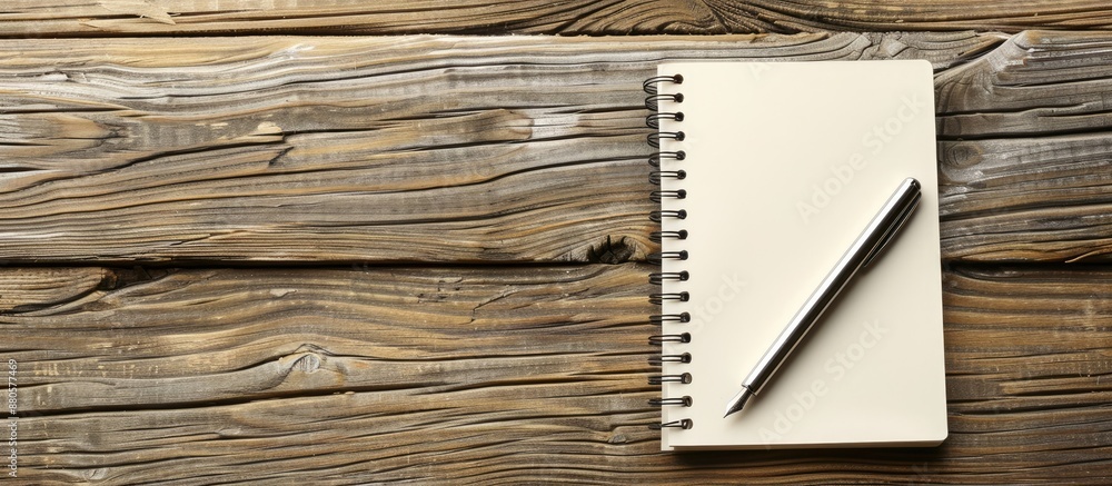 Fototapete office wooden table with a pen placed on a blank notepad offering a copy space image