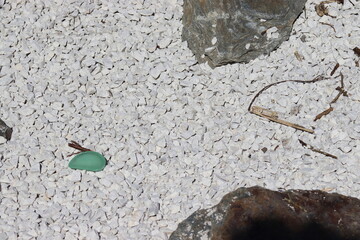 Decorative stones in the garden. Garden arrangements. White stones, colored stones in the garden.