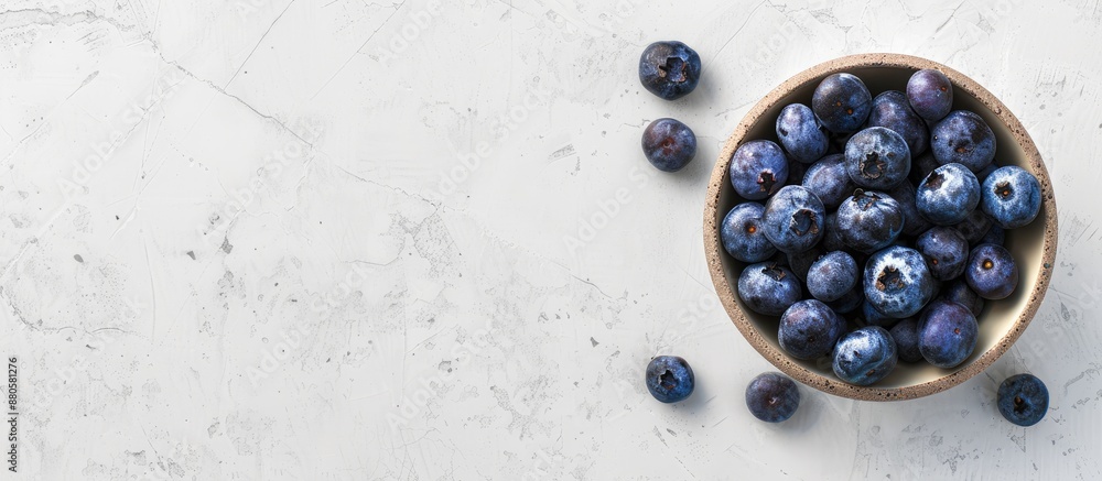 Poster top view of a bowl filled with blueberries on a wooden surface against a white concrete background w