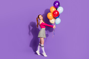 Full length photo of cheerful pretty lady dressed pink top walking rising balloons bouquet empty space isolated violet color background