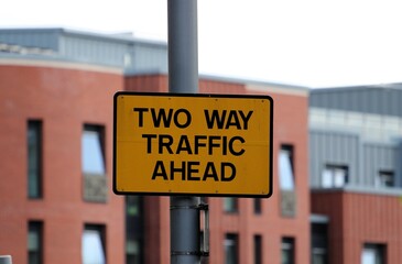 Obraz premium yellow road sign with the inscription two-way traffic ahead