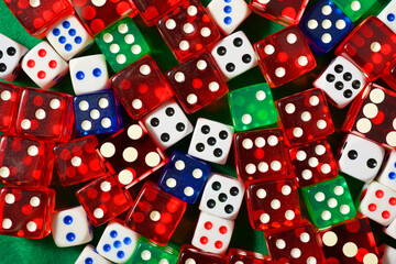 Game dice of different sizes and classes on a green mat.