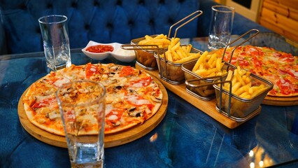 Pizza and Fries on a Restaurant Table