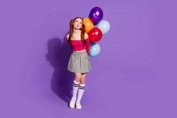 Full length photo of adorable lovely girl wear off shoulders top sending kiss holding balloons bunch empty space isolated purple color background