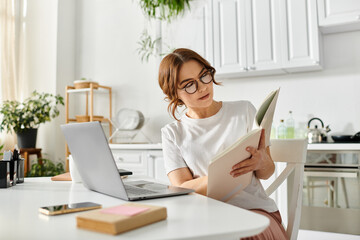 Middle aged woman engrossed in a book at a cozy kitchen table.
