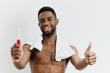 Confident man with toothbrush giving thumbs up gesture, promoting oral hygiene and dental health awareness
