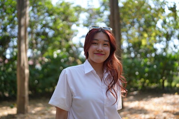 Portrait of asian pretty young woman red hair in white shirt positive smiling cheerful girl