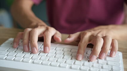 Hands man typing on white keyboard.