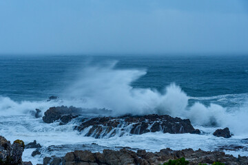 Wild, winter storm conditions at Kwaaiwater with ocean waves breaking onto the rocky Hermanus coastline. Whale Coast, Overberg, Western Cape, South Africa.
