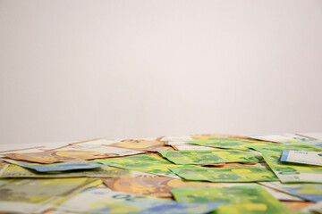 Euro banknotes of various denominations are scattered on a white surface