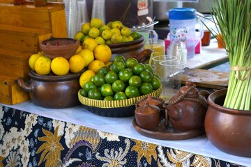 Group of orange and tangerine on clay pot and traditional container, Indonesian traditional market display