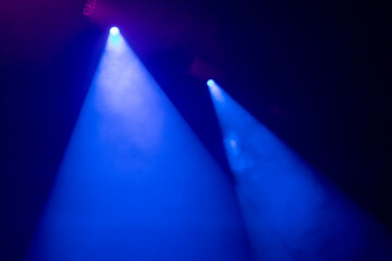 An empty stage, lit by spotlights and smoke before the performance
