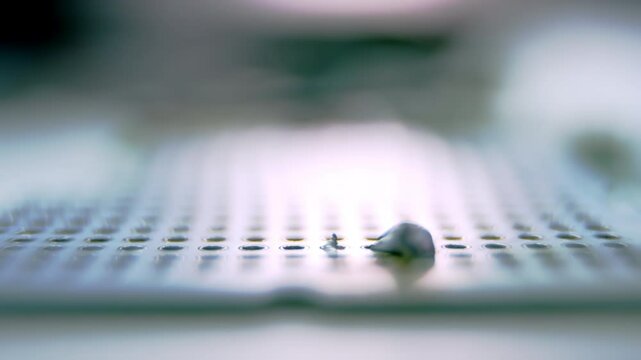 Drop of melted metal solder on detail panel under light. Soldering device melts metal and drop of metal falls on panel closeup