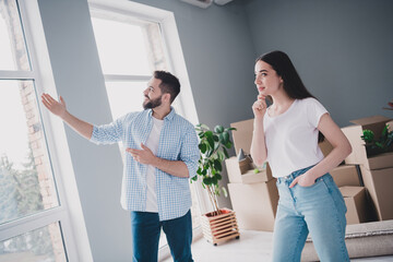 Photo of two young partners show room think relocating moving box package new modern flat indoors