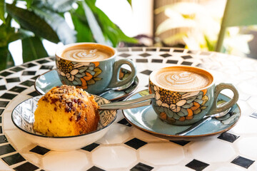 A cuppo of coffee latte with art and cakes in a cafe with relaxing and peaceful ambient surrounding