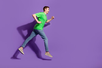 Full body portrait of nice young man jump run empty space wear t-shirt isolated on purple color background