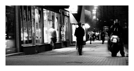 man in front of storefront and motorcycle black and white abstraction
