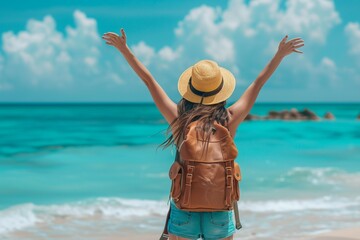Happy woman with backpack standing with arms up at the beach