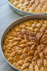 Turkish pistachio pastry dessert, Baklava on a tray and wooden table.