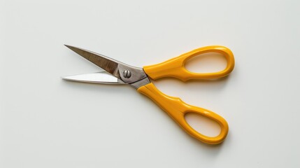 Yellow scissors from above on a white backdrop