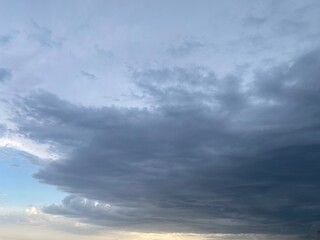 Obraz premium Blue, cloudy, moody sky. The sun is breaking through the cloud