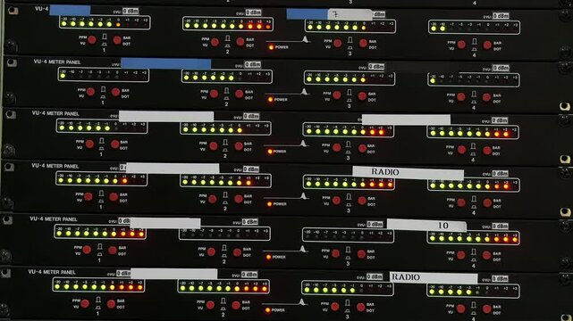 VU Meters Peaking on a Lighted Audio Mixing Console. Close Up. 4K Resolution.