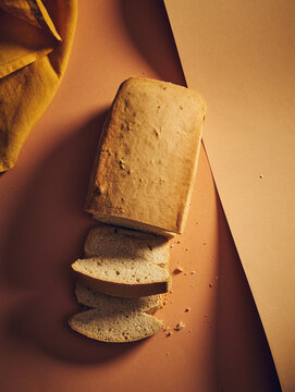 top view of bread and half of it in slices on an orange background