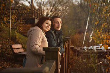 Fototapeta premium happy married couple hugging on the embankment in autumn
