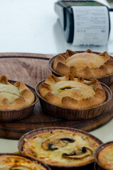 Delicious and fresh desserts in the form of tartlets on display behind glass