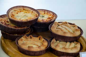 Delicious and fresh desserts in the form of tartlets on display behind glass