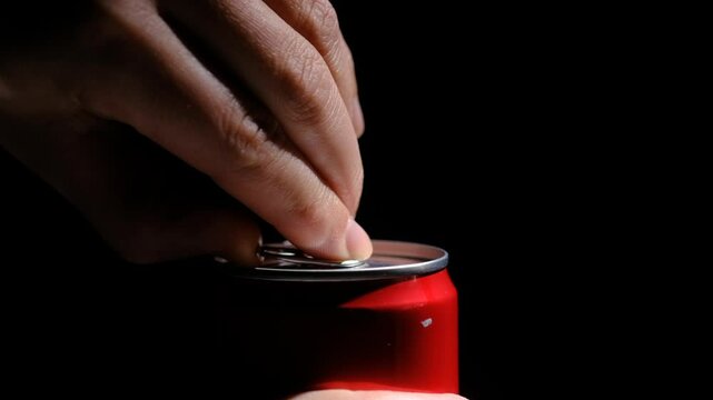 opens a can of soda in close-up