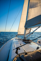 Yacht sailing in an open sea. Close-up view of the deck, mast and sails. Yachting concept